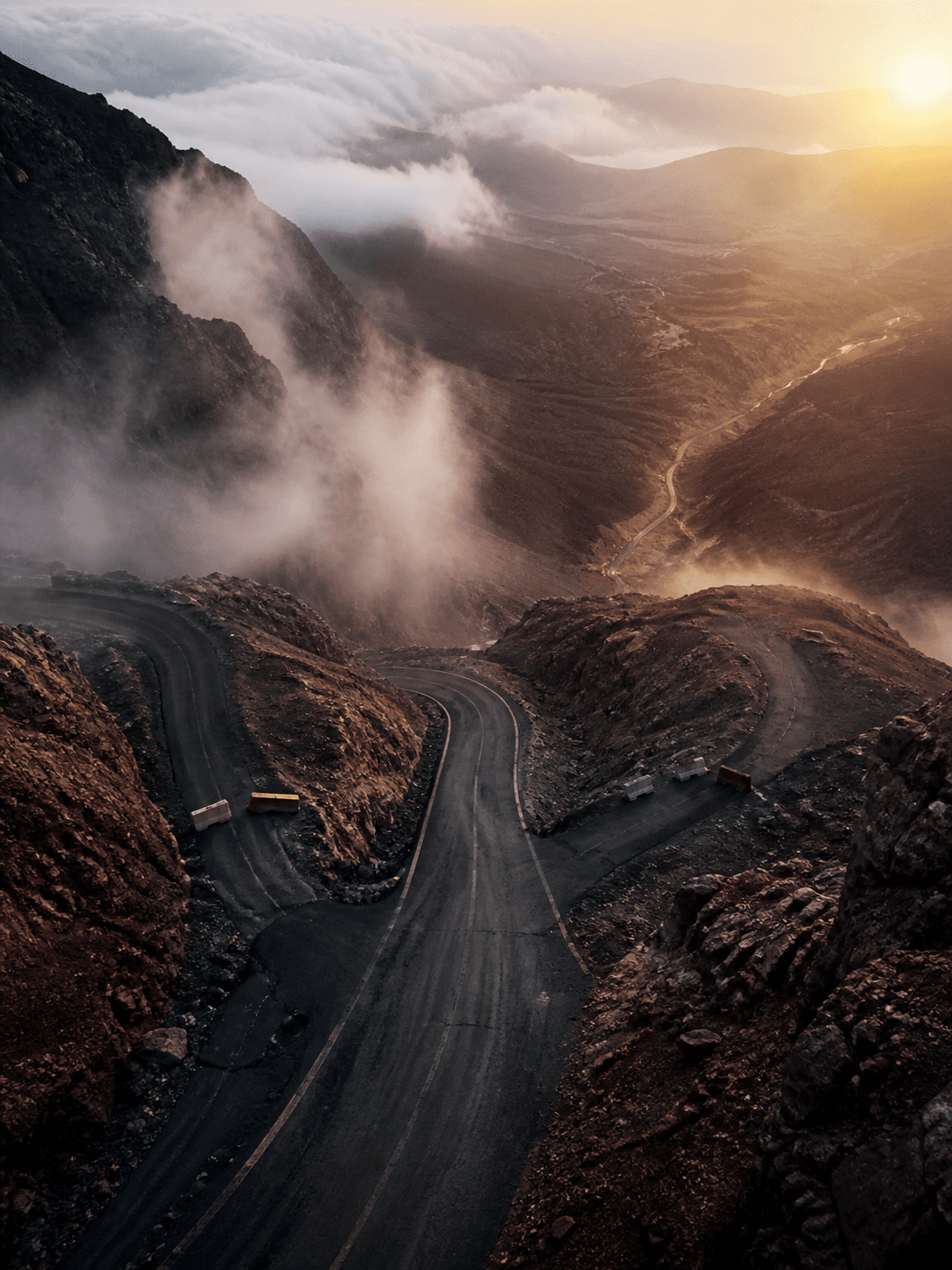 Mountain routes divide in dawn mist, with only one clear route continuing onward.